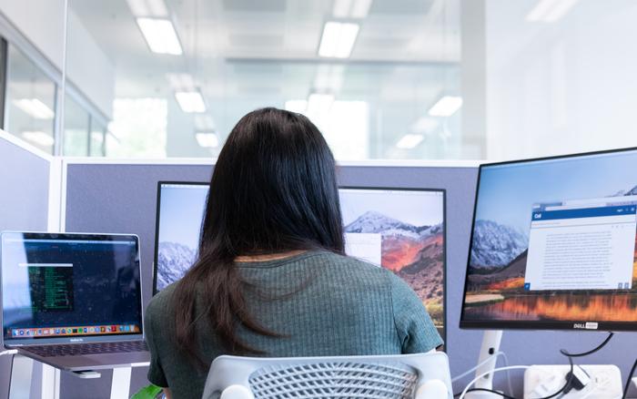 A Crick researcher reading a scientific paper on a screen.
