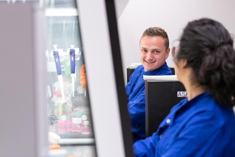 Two researchers wearing blue lab coats