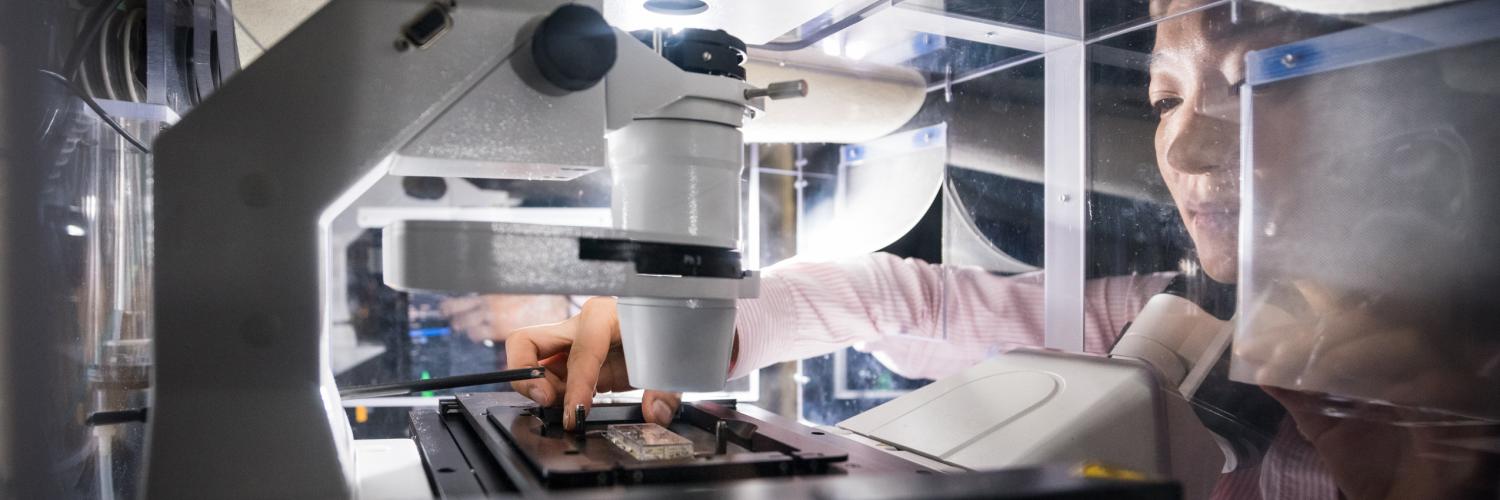 Minee Choi using a microscope