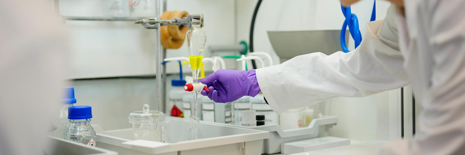 A hand holds a chemical test in the lab