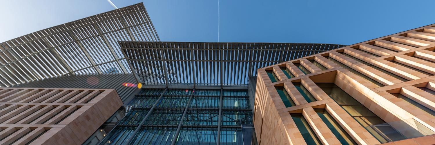 The exterior of the Francis Crick institute against a blue sky.