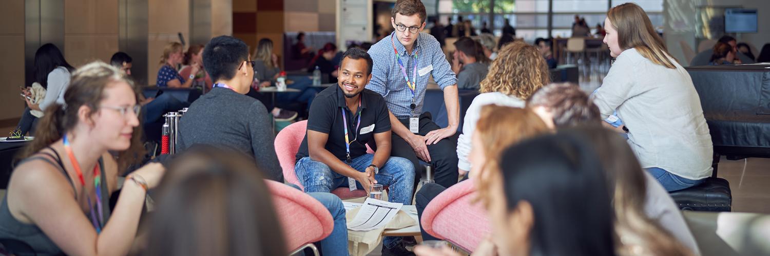 A group of students talk to each other informally on couches