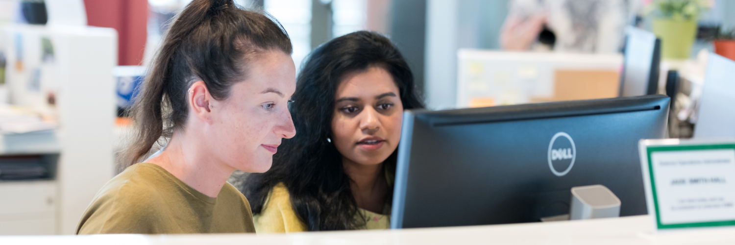 Two women look at a computer screen in a Crick hub