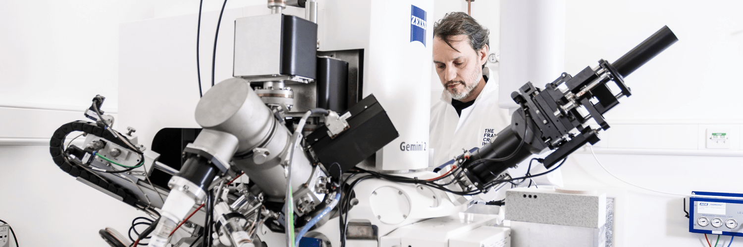 Person standing behind a microscope