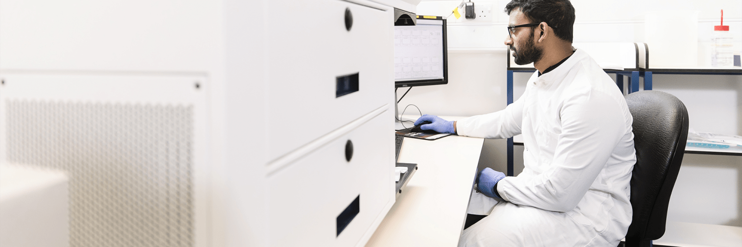 A man sits in front of a scientific instrument
