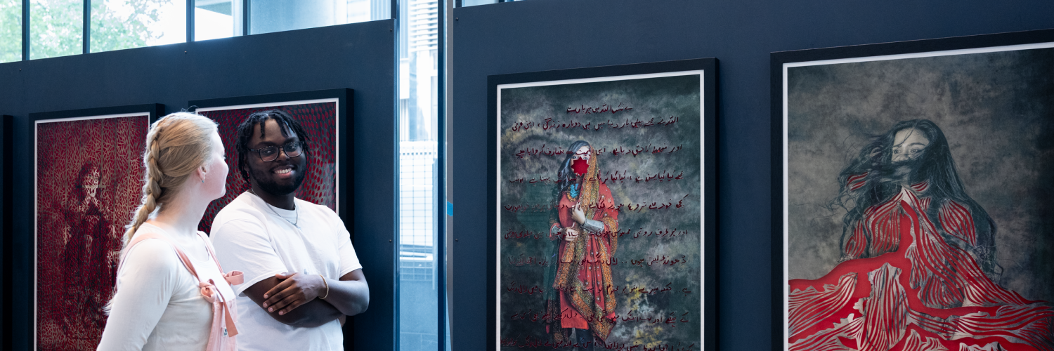 Two people look at images in a gallery